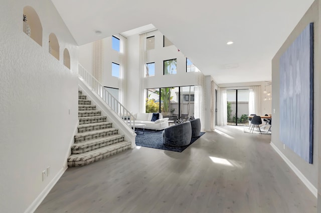 living room with a towering ceiling and hardwood / wood-style floors