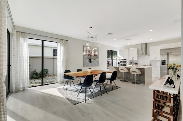 dining area featuring sink and an inviting chandelier