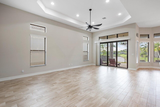 spare room featuring a tray ceiling and ceiling fan