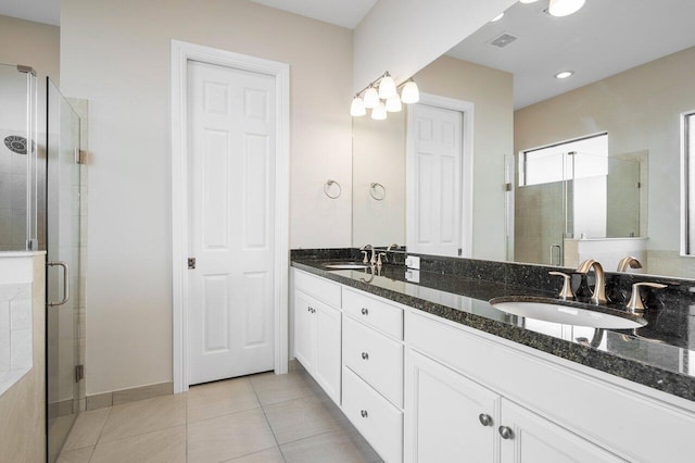 bathroom with tile patterned flooring, vanity, and a shower with door