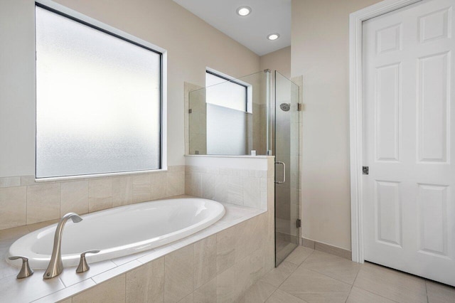 bathroom featuring tile patterned flooring and shower with separate bathtub