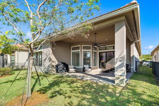 rear view of property featuring a yard, a patio, and ceiling fan