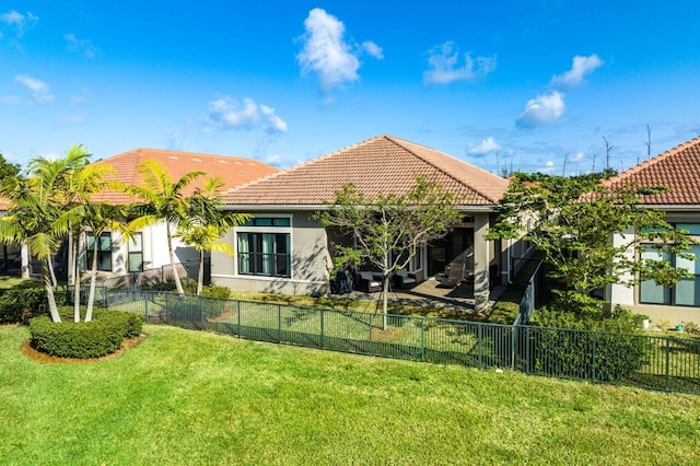 back of property with a lawn and a patio