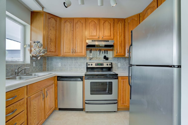 kitchen featuring decorative backsplash, light tile patterned floors, sink, and appliances with stainless steel finishes