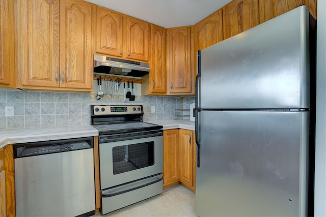 kitchen featuring decorative backsplash, light tile patterned floors, and stainless steel appliances