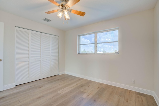 unfurnished bedroom featuring a closet, light hardwood / wood-style flooring, and ceiling fan