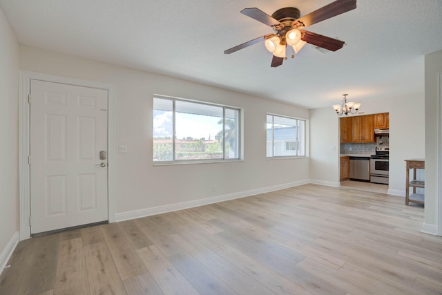 unfurnished living room featuring a textured ceiling, ceiling fan with notable chandelier, and light wood-type flooring