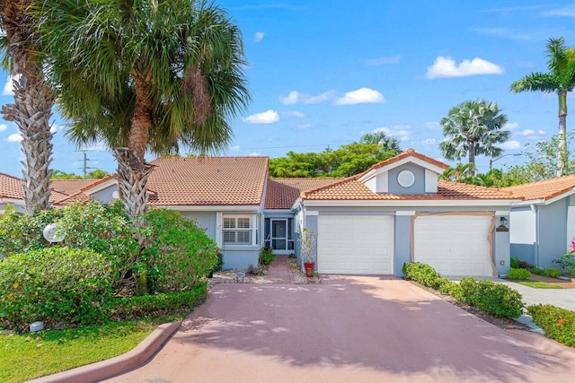 9904 Summerbrook Ter Unit C, Boynton Beach, FL 33437 - view of front of property with stucco siding, an attached garage, a tile roof, and concrete driveway