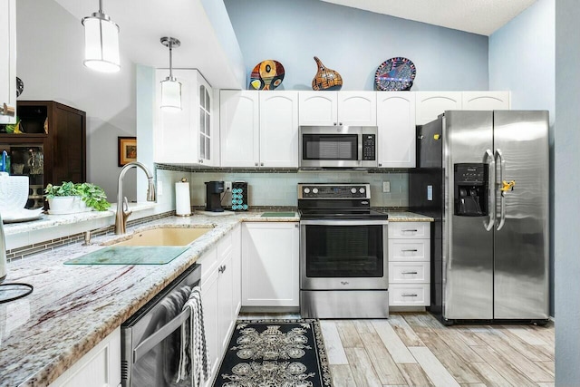 kitchen with pendant lighting, white cabinetry, sink, and stainless steel appliances