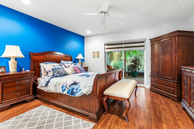 bedroom with a textured ceiling, access to outside, ceiling fan, and dark wood-type flooring