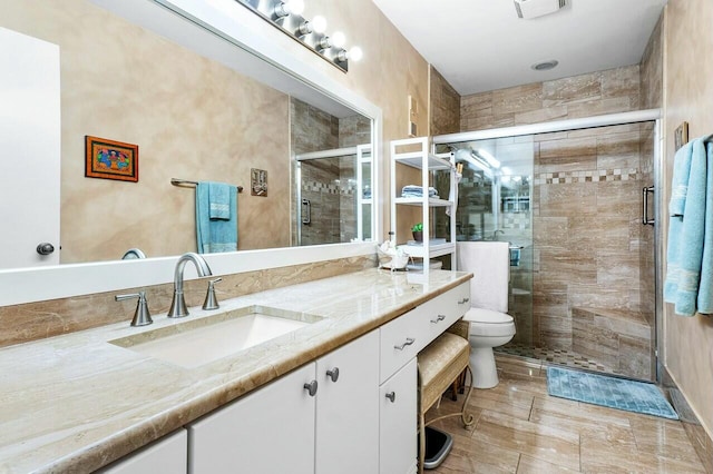 bathroom featuring vanity, toilet, and a shower with shower door