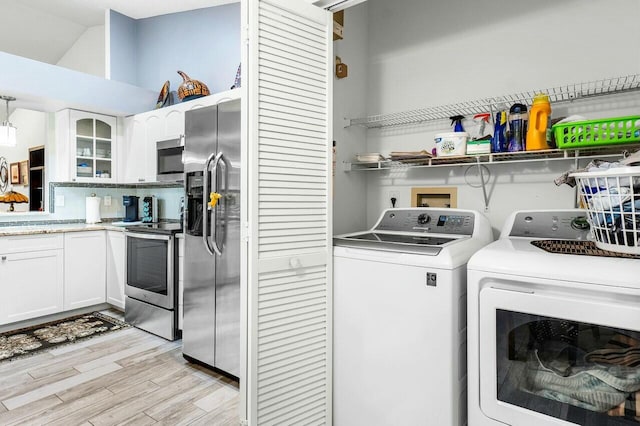 clothes washing area featuring light hardwood / wood-style floors and washing machine and clothes dryer