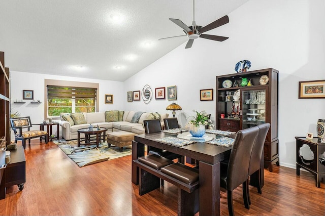 dining room featuring hardwood / wood-style flooring, ceiling fan, a textured ceiling, and high vaulted ceiling