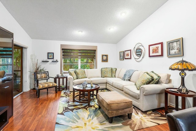 living room featuring a textured ceiling, dark wood-type flooring, and lofted ceiling