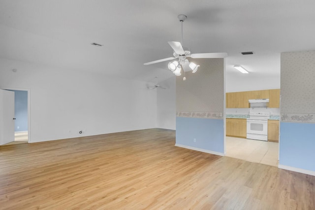 empty room with ceiling fan, light hardwood / wood-style floors, and vaulted ceiling