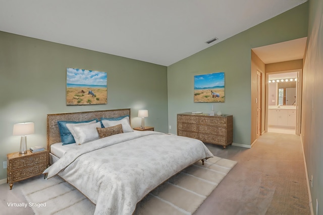 carpeted bedroom featuring connected bathroom and lofted ceiling