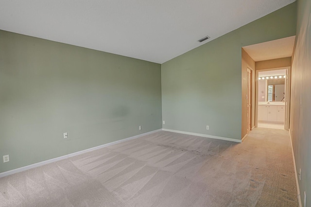 carpeted spare room with vaulted ceiling