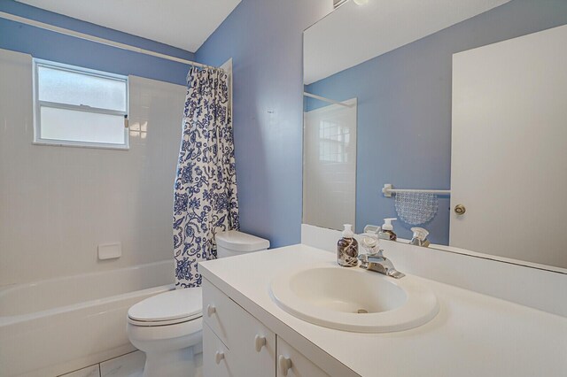 full bathroom with vanity, shower / bathtub combination with curtain, and toilet