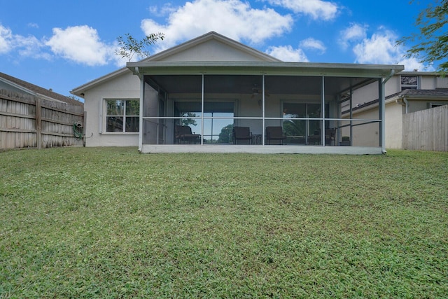 back of house featuring a lawn and a sunroom