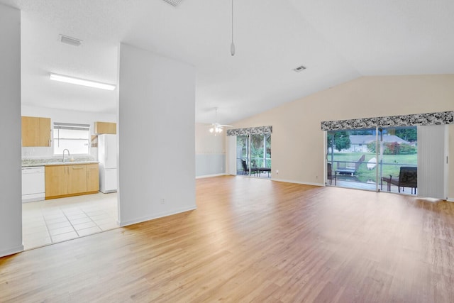 unfurnished living room with light hardwood / wood-style floors, vaulted ceiling, ceiling fan, and sink