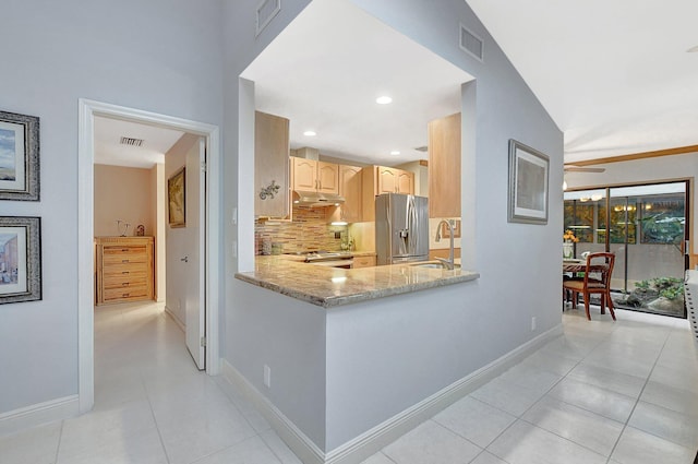 kitchen featuring tasteful backsplash, stainless steel fridge with ice dispenser, light stone counters, lofted ceiling, and light brown cabinetry