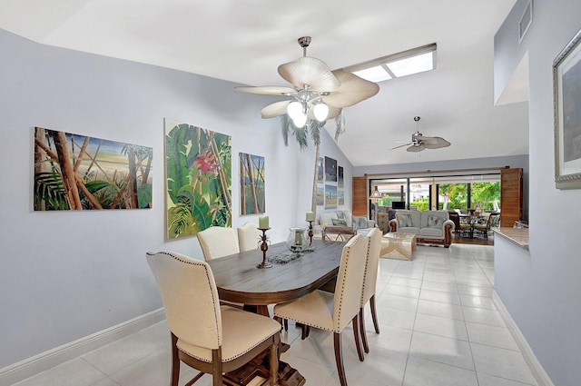 dining room with ceiling fan, light tile patterned floors, and vaulted ceiling