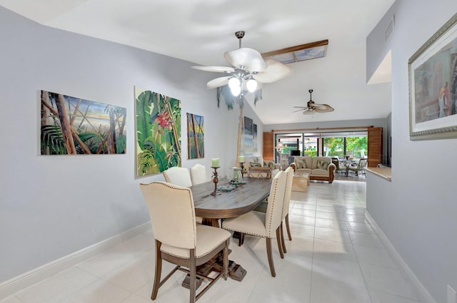 tiled dining space with ceiling fan and vaulted ceiling