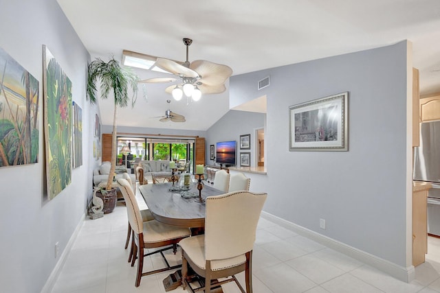 tiled dining room featuring ceiling fan and lofted ceiling