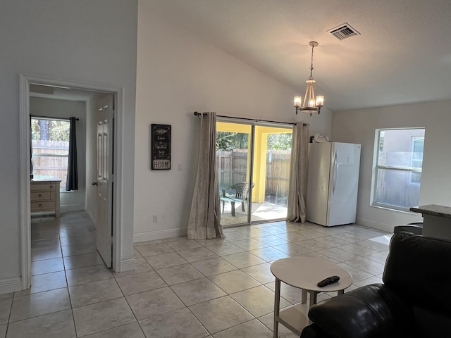 tiled living room featuring an inviting chandelier and lofted ceiling