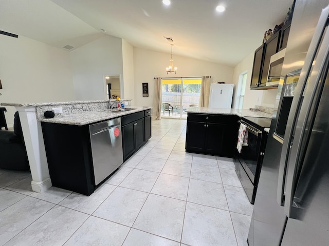 kitchen with pendant lighting, vaulted ceiling, stainless steel appliances, and an island with sink