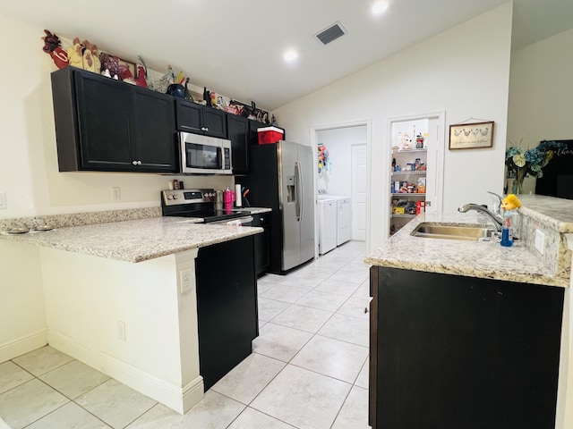 kitchen featuring sink, stainless steel appliances, separate washer and dryer, vaulted ceiling, and kitchen peninsula