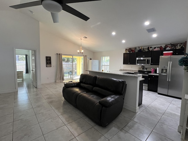 living room featuring light tile patterned flooring, high vaulted ceiling, and ceiling fan with notable chandelier