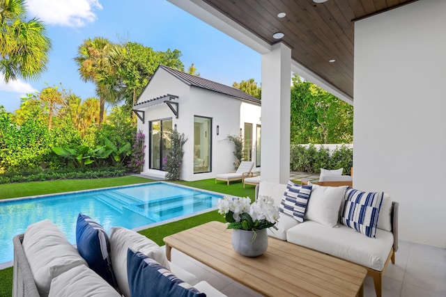 view of pool with an outdoor living space, a patio, and an outdoor structure