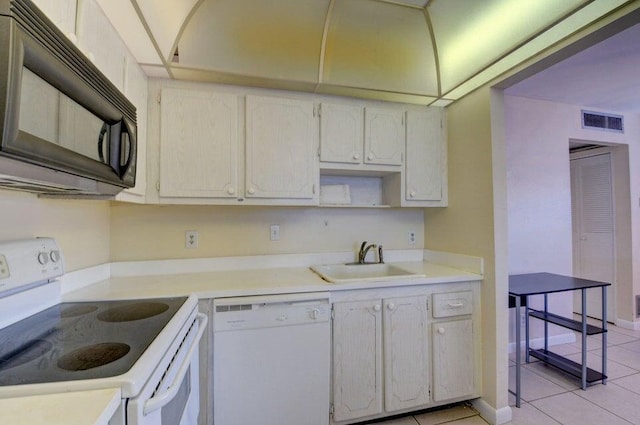 kitchen featuring light tile patterned flooring, white appliances, and sink