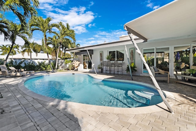 view of pool featuring a patio area and a bar