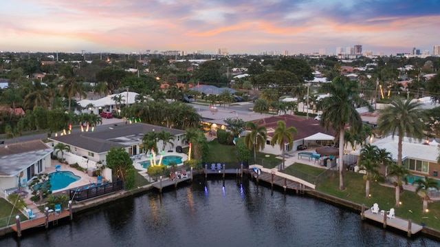 aerial view at dusk featuring a water view