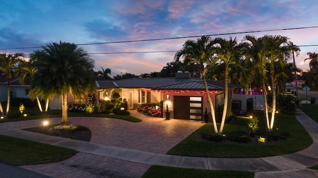 view of front of house with a garage and a lawn