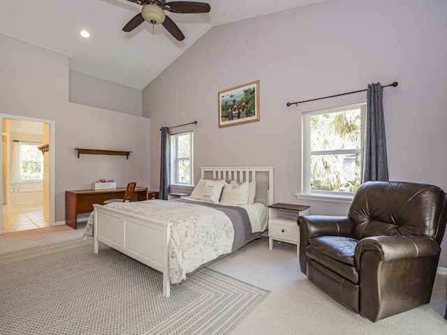 bedroom featuring ceiling fan, ensuite bath, lofted ceiling, and multiple windows