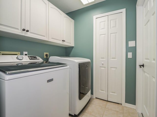 washroom featuring light tile patterned flooring, cabinets, and separate washer and dryer