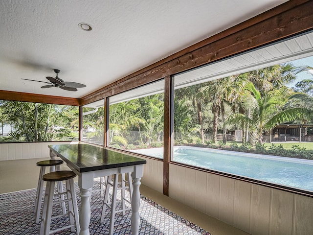 unfurnished sunroom with ceiling fan