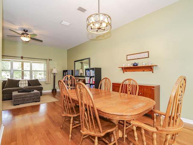 dining area featuring light hardwood / wood-style floors and ceiling fan with notable chandelier