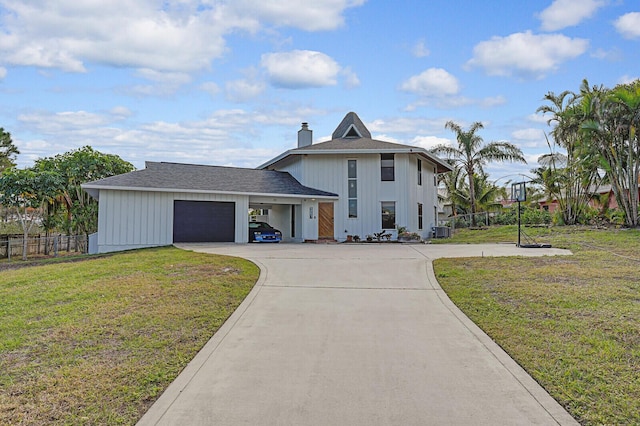 view of front facade with cooling unit, a garage, and a front yard