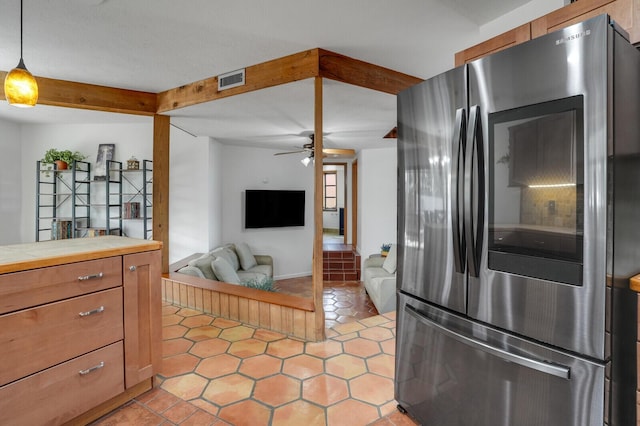 kitchen featuring pendant lighting, ceiling fan, light tile patterned floors, and stainless steel refrigerator