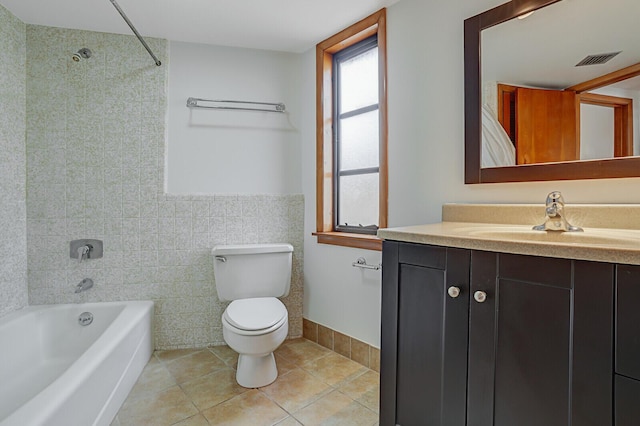 full bathroom with vanity, tiled shower / bath combo, tile walls, tile patterned flooring, and toilet