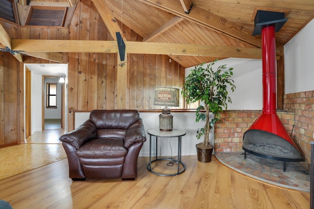 living area with vaulted ceiling with beams, wood walls, light hardwood / wood-style flooring, and wooden ceiling