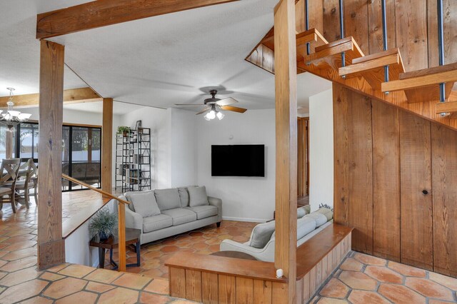 living room featuring ceiling fan with notable chandelier and light tile patterned floors