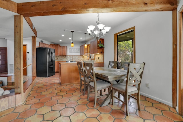 dining area featuring beam ceiling, sink, light tile patterned floors, and a chandelier