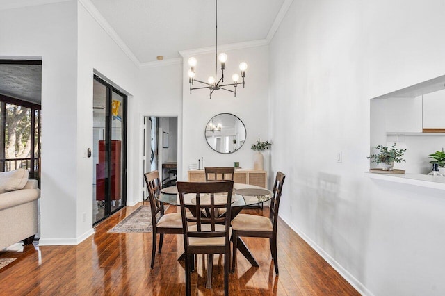 dining space with a chandelier, dark wood-type flooring, and ornamental molding