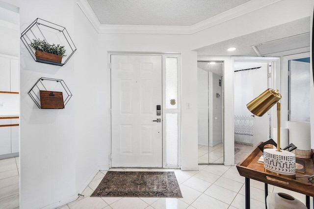 tiled entryway featuring a textured ceiling and ornamental molding