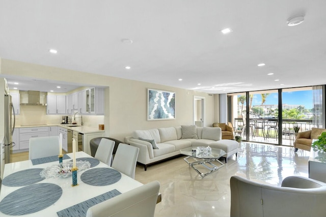 living room featuring sink and a wall of windows